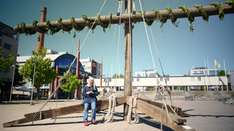 Woman sitting on the wooden structure.