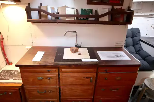 Showing work exhibited on a wooden desk inside the ship.